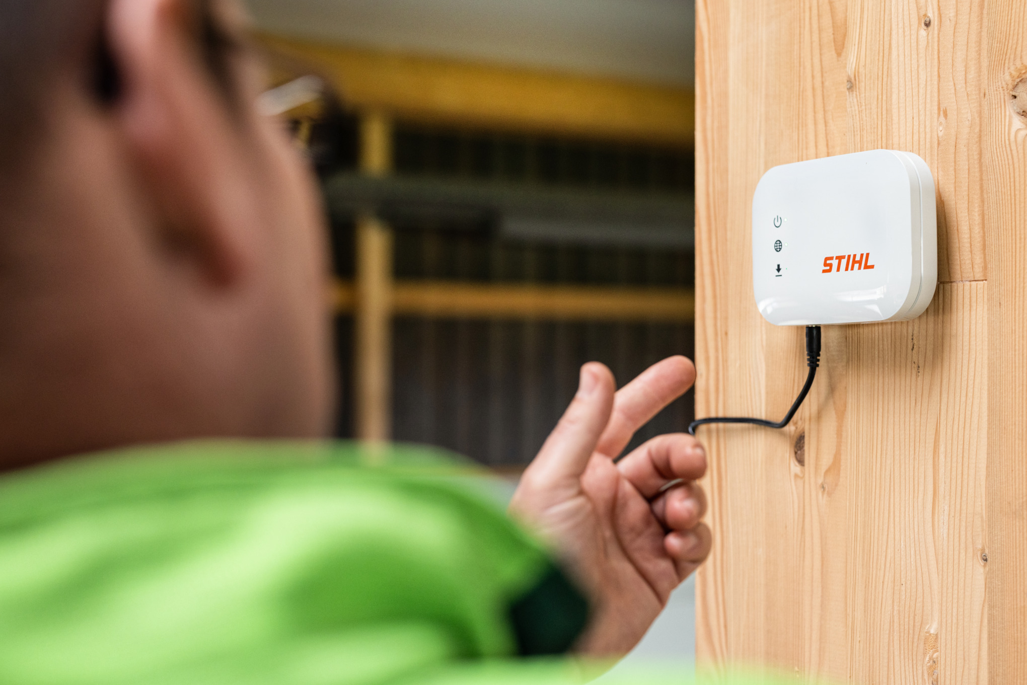 Κοντινή λήψη ενός ατόμου που δείχνει το STIHL Connected mobile Box