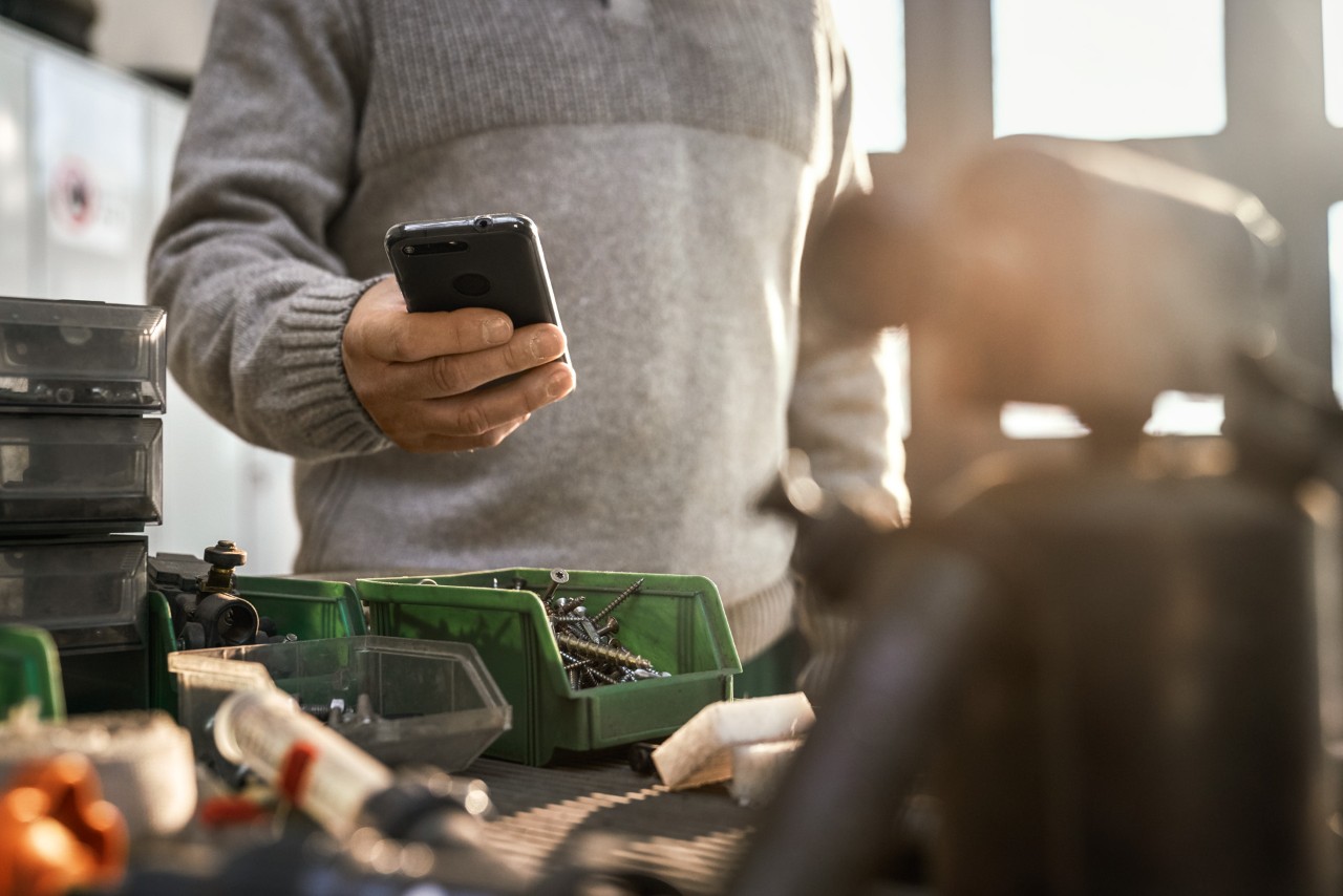 Άτομο με smartphone σε συνεργείο