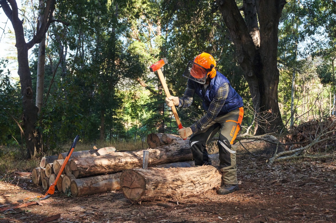 Άτομο τεμαχίζει ένα τμήμα κορμού με το τσεκούρι σχισίματος